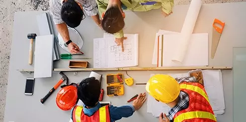 designer and engineer conferring over drawings